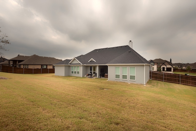 back of property with a yard and a patio area