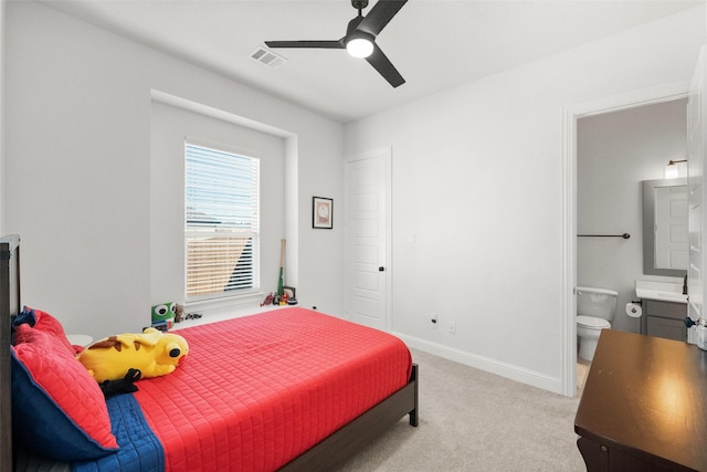 bedroom featuring light colored carpet, visible vents, ensuite bathroom, ceiling fan, and baseboards