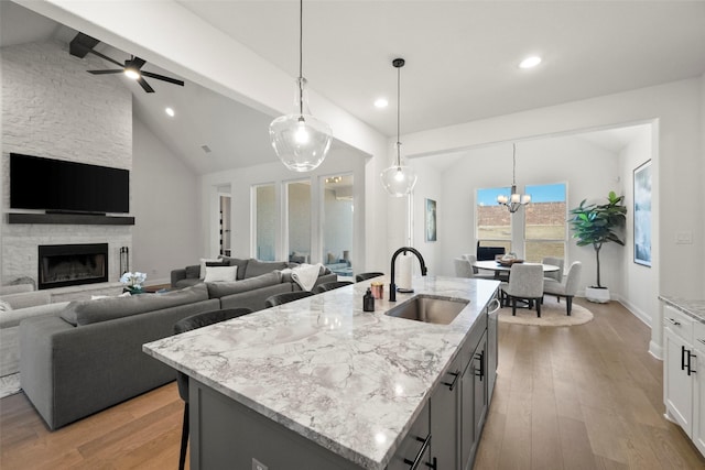 kitchen with open floor plan, white cabinetry, a sink, and an island with sink