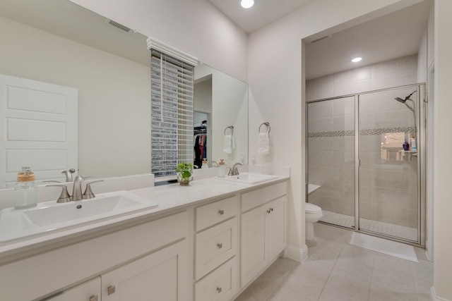 bathroom featuring toilet, vanity, tile patterned floors, and a shower with shower door