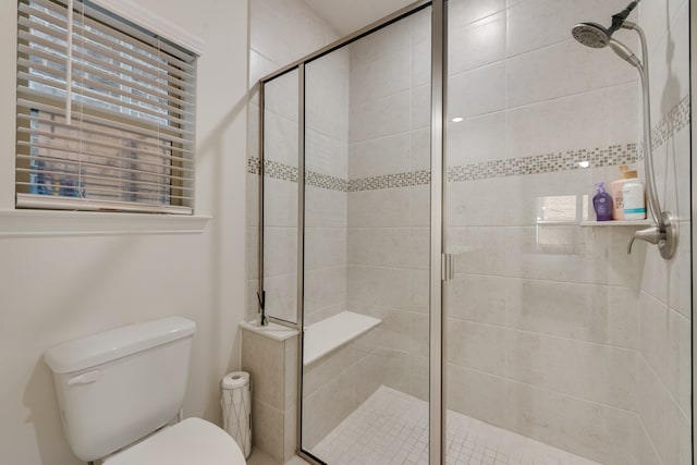 bathroom featuring toilet and an enclosed shower