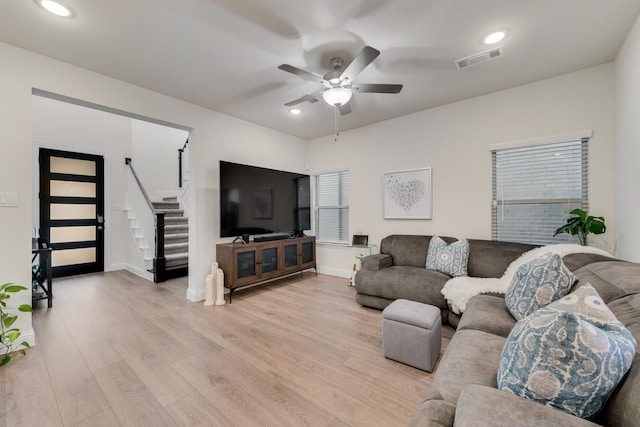 living room with light hardwood / wood-style floors and ceiling fan