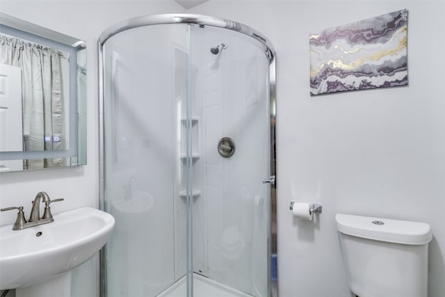 bathroom with walk in shower, sink, and toilet