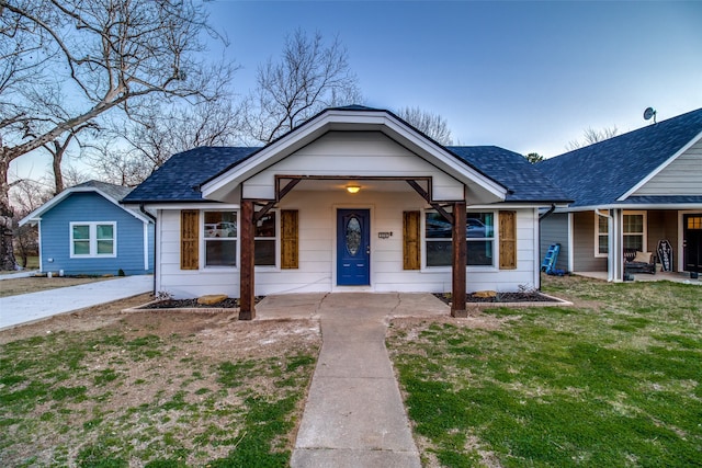 bungalow-style home featuring covered porch and a front yard