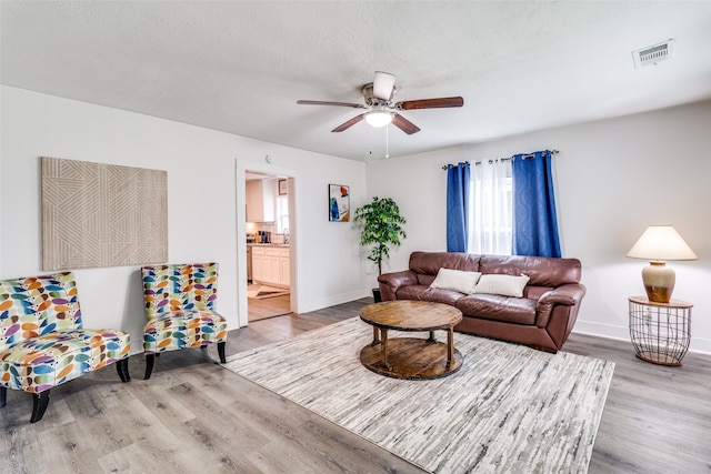 living room featuring light hardwood / wood-style flooring and ceiling fan