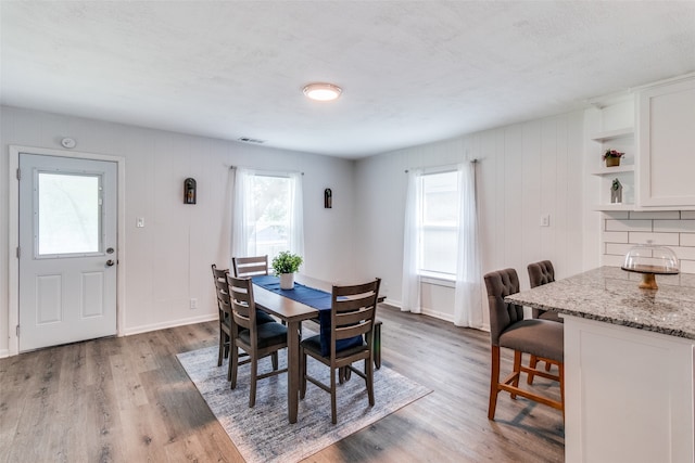 dining space with a textured ceiling, dark hardwood / wood-style floors, and plenty of natural light