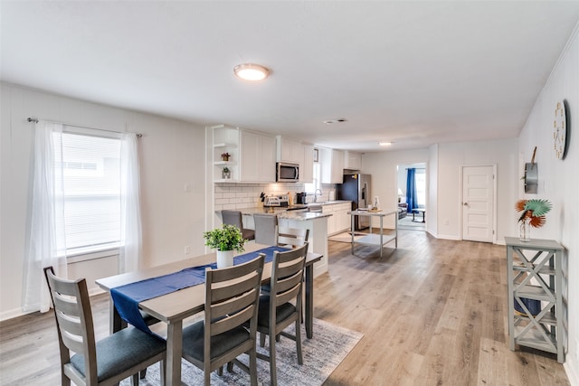 dining room featuring sink and light wood-type flooring