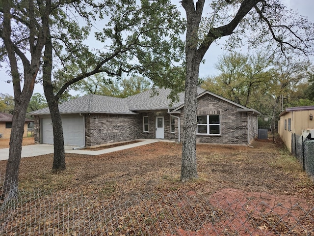 ranch-style house featuring a garage and central AC unit