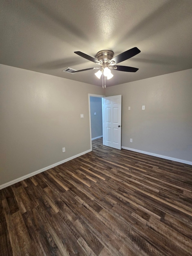 empty room with a textured ceiling, dark hardwood / wood-style floors, and ceiling fan