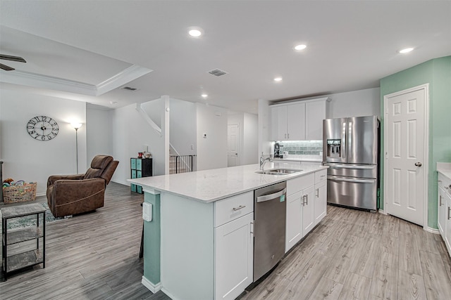 kitchen featuring a center island with sink, white cabinets, and stainless steel appliances