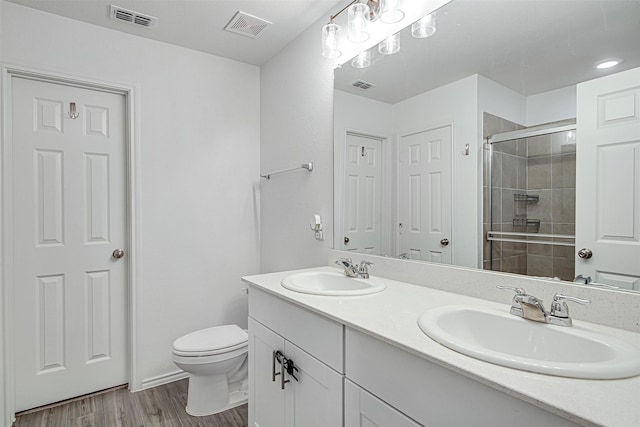 bathroom with vanity, hardwood / wood-style flooring, toilet, and a shower with shower door