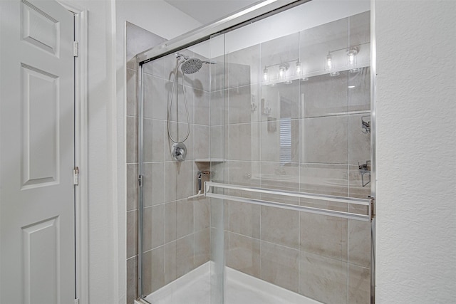 bathroom featuring a shower with shower door