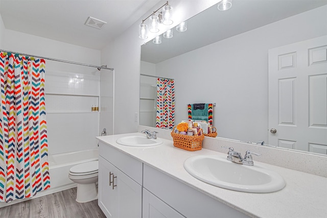 full bathroom featuring hardwood / wood-style floors, vanity, shower / bath combination with curtain, and toilet