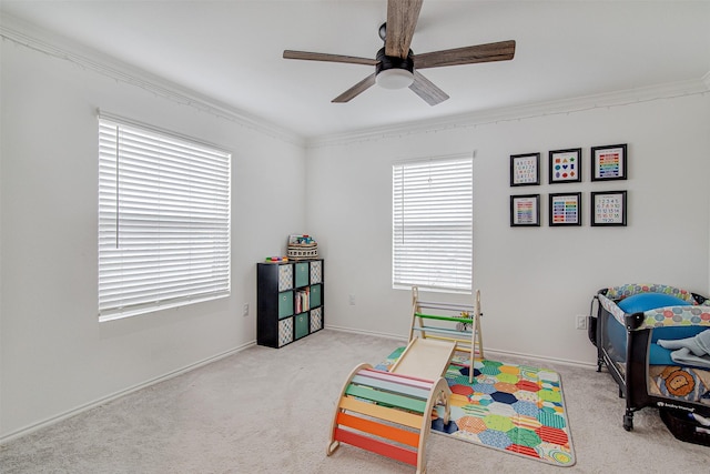 recreation room featuring light carpet, ceiling fan, and crown molding