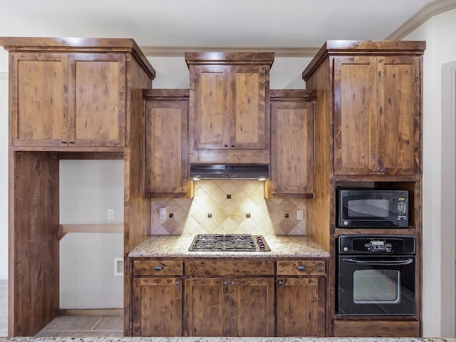 kitchen with light stone counters, decorative backsplash, black appliances, light tile patterned flooring, and crown molding