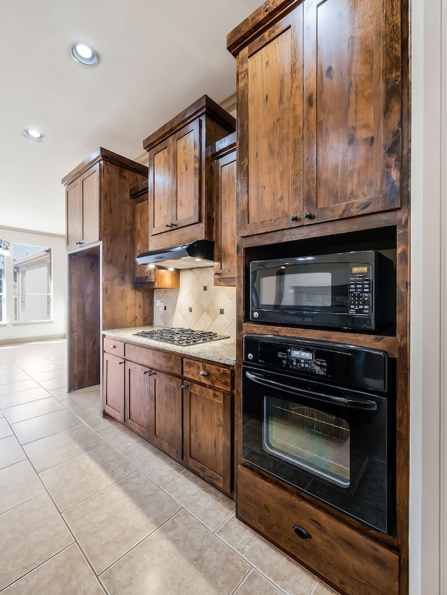 kitchen with black appliances, light stone countertops, decorative backsplash, and light tile patterned floors