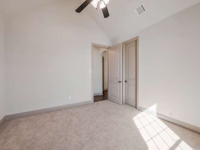 carpeted spare room with ceiling fan and high vaulted ceiling