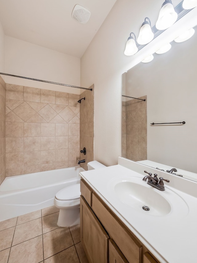 full bathroom featuring toilet, vanity, tiled shower / bath, and tile patterned flooring