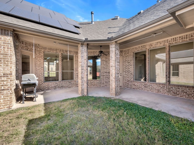 exterior space featuring a patio, solar panels, a yard, and ceiling fan