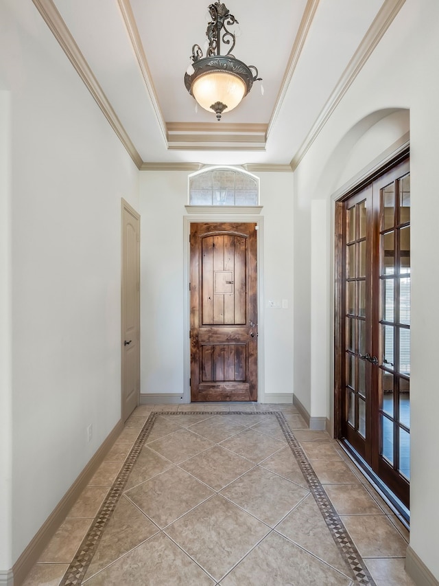 foyer entrance with ornamental molding, french doors, light tile patterned floors, and a tray ceiling