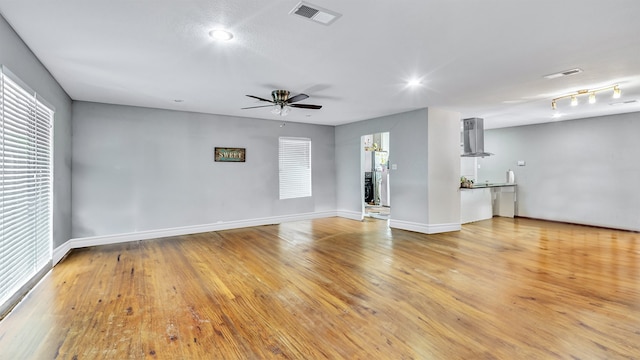 unfurnished living room featuring ceiling fan and light hardwood / wood-style floors