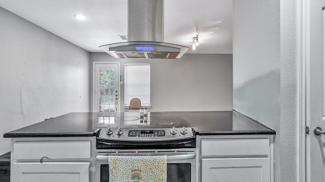 kitchen with white cabinetry, island range hood, and stainless steel electric stove