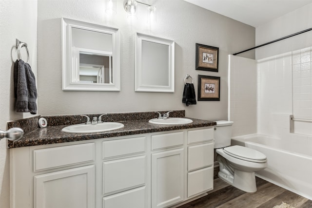 full bathroom with hardwood / wood-style floors, vanity, toilet, and bathtub / shower combination