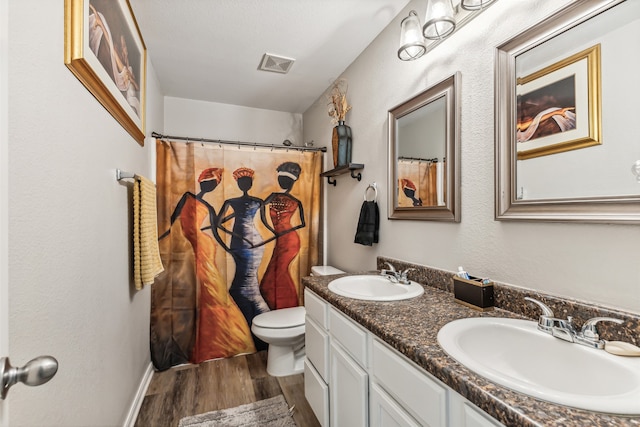 bathroom featuring vanity, hardwood / wood-style flooring, and toilet