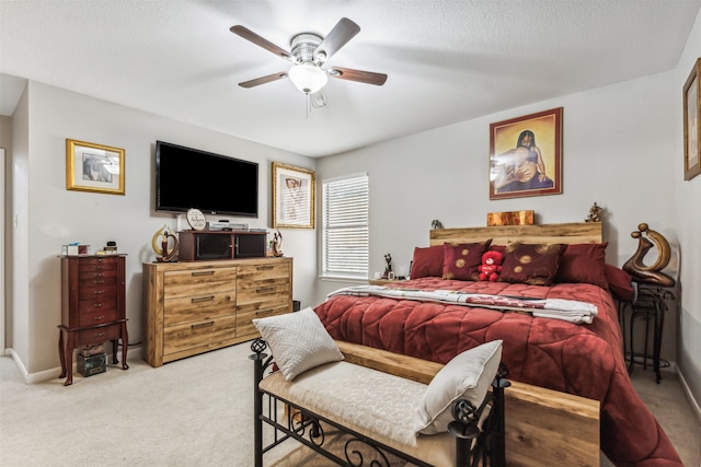 carpeted bedroom featuring a textured ceiling and ceiling fan