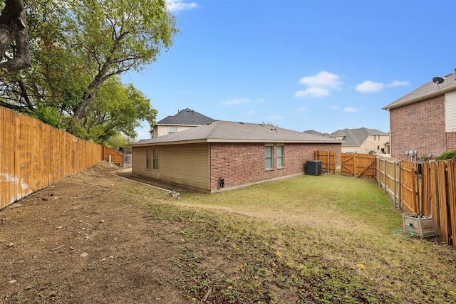 back of house with a lawn and central AC