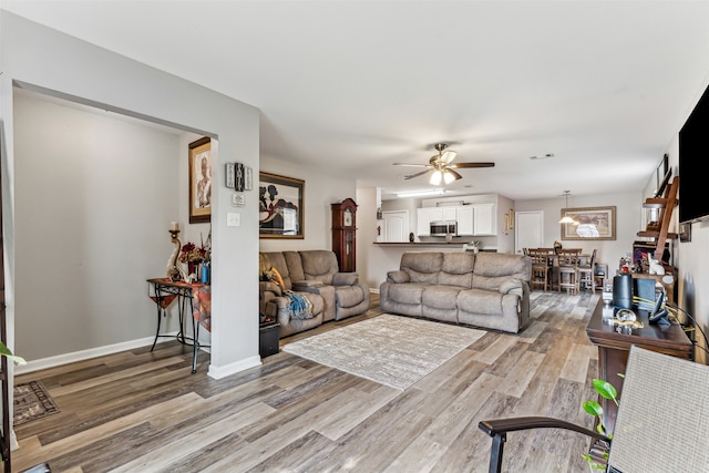 living room with hardwood / wood-style floors and ceiling fan