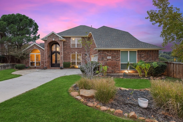 view of front of home featuring a lawn and french doors