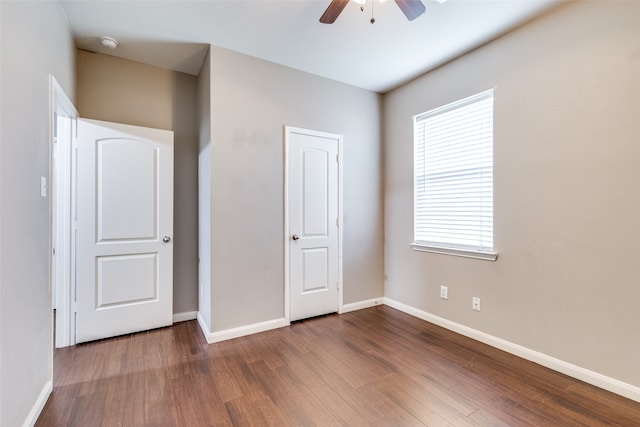 unfurnished bedroom with ceiling fan, dark hardwood / wood-style floors, and a closet