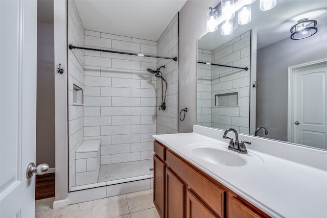 bathroom featuring a tile shower, vanity, and tile patterned floors