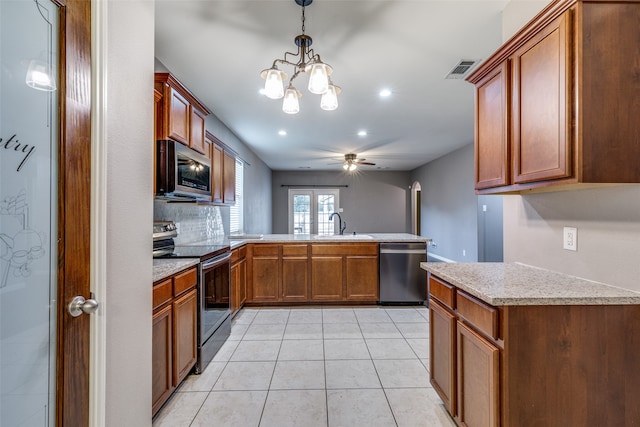 kitchen featuring kitchen peninsula, sink, light tile patterned flooring, appliances with stainless steel finishes, and decorative light fixtures