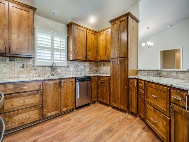 kitchen featuring sink, tasteful backsplash, light stone counters, stainless steel dishwasher, and light hardwood / wood-style floors