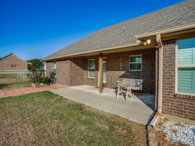 back of house with a lawn and a patio