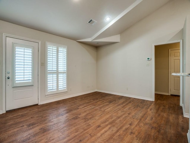 unfurnished room featuring vaulted ceiling and dark hardwood / wood-style floors