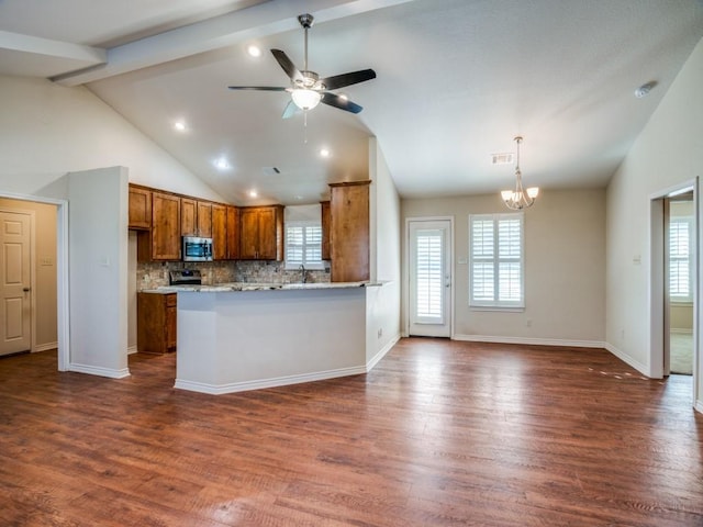 kitchen with tasteful backsplash, a healthy amount of sunlight, beam ceiling, and kitchen peninsula