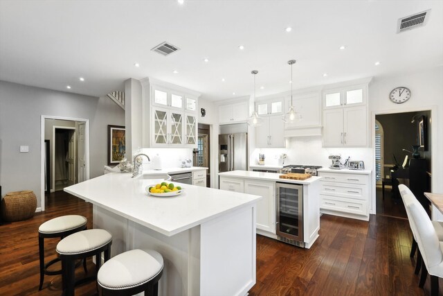 kitchen with wine cooler, white cabinetry, pendant lighting, dark wood-type flooring, and kitchen peninsula