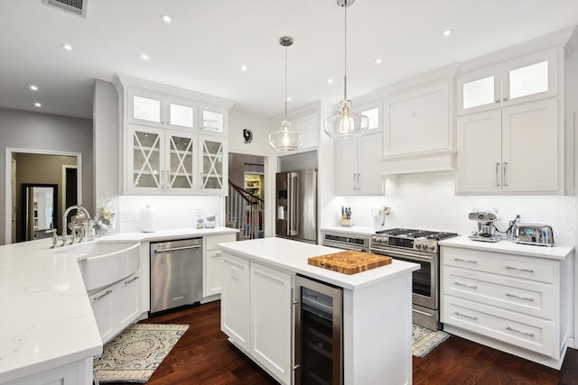 kitchen featuring kitchen peninsula, white cabinets, wine cooler, and appliances with stainless steel finishes