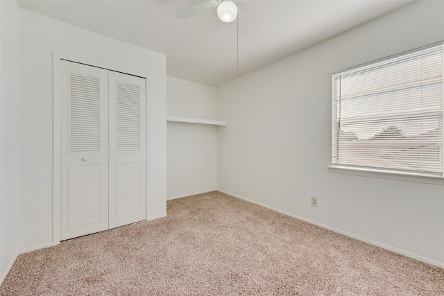 unfurnished bedroom featuring a closet, light colored carpet, and ceiling fan