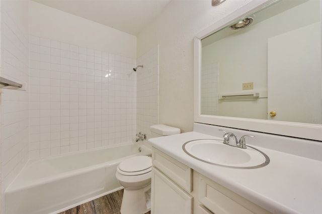 full bathroom with vanity, hardwood / wood-style flooring, tiled shower / bath, and toilet