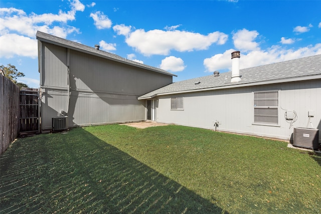 back of property featuring cooling unit and a yard