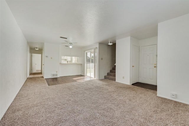 unfurnished living room with carpet and ceiling fan