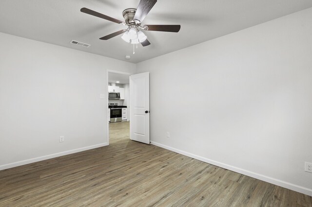 unfurnished room with hardwood / wood-style flooring and ceiling fan