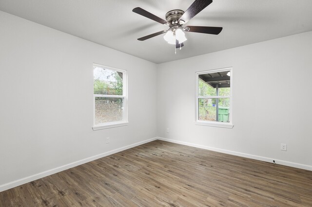 empty room featuring a wealth of natural light, hardwood / wood-style flooring, and ceiling fan