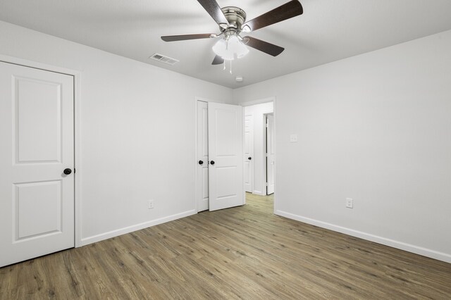 unfurnished bedroom with ceiling fan and light wood-type flooring