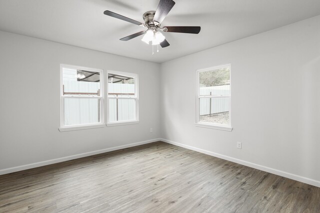 spare room with hardwood / wood-style floors, a healthy amount of sunlight, and ceiling fan