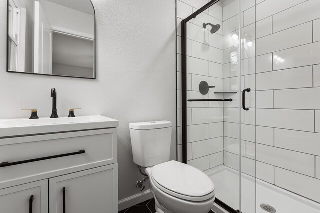 bathroom featuring vanity, toilet, and a shower with door